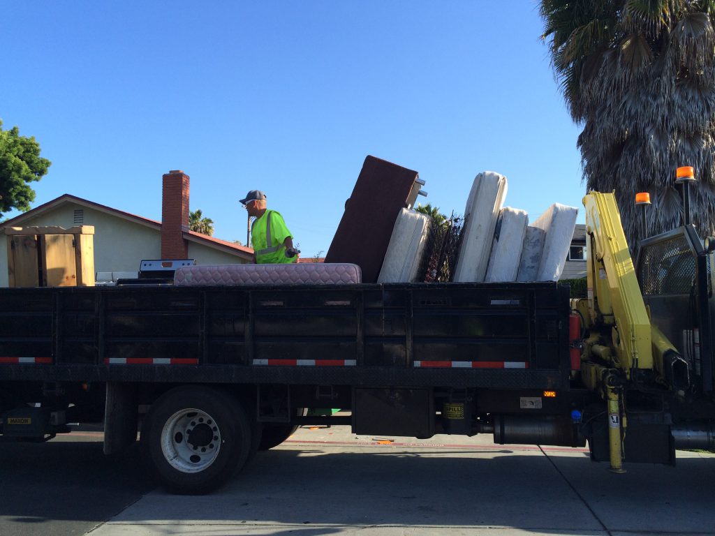 A city worker loads items onto a truck as part of San Jose's large item collection program