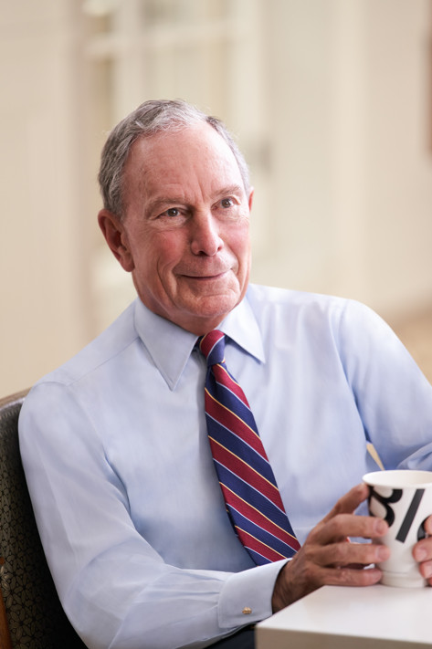 Photo of Mike Bloomberg at a desk.